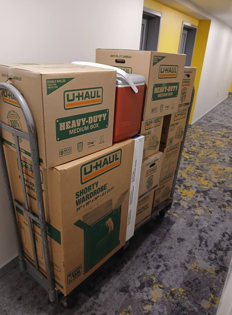 Uhaul boxes on a moving cart in the hallway of an apartment building